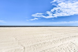 A wide sandy beach with footprints leading to the water. - Hilton Head Resort Villa - 200 Yards From Beach! (Hilton Head Island)