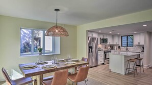 A modern kitchen with stainless steel appliances, a wooden dining table, and a large window. - Hilton Head Escape w/ Private Beach Access! (Hilton Head Island)