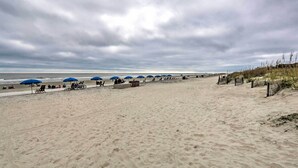 A sandy beach with blue umbrellas and beach chairs. - Hilton Head Escape w/ Private Beach Access! (Hilton Head Island)