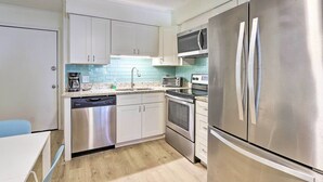 A modern kitchen with stainless steel appliances, a dishwasher, a microwave, and a toaster.