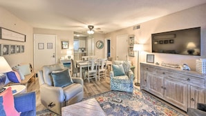A living room with a sofa, armchair, and a dining area with chairs and a table. - Half-mi to Beach: Hilton Head Condo w/ Lagoon View (Hilton Head Island)
