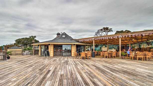Une terrasse en bois avec des sièges extérieurs et un petit bâtiment doté d’un toit en pente.