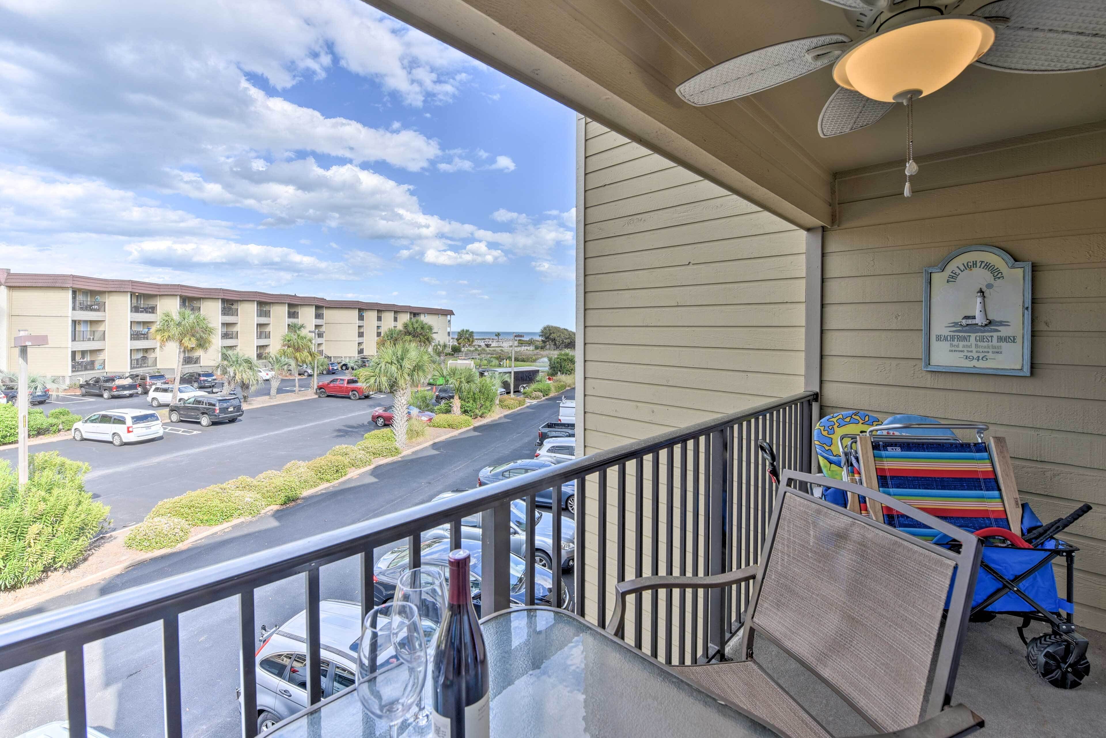 A balcony with a view of a parking lot and a building.