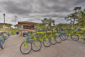 A bike rental station with multiple bicycles, a small kiosk, and a flag. - Beach View, Pool & Tennis: Hilton Head Island Unit (Hilton Head Island)
