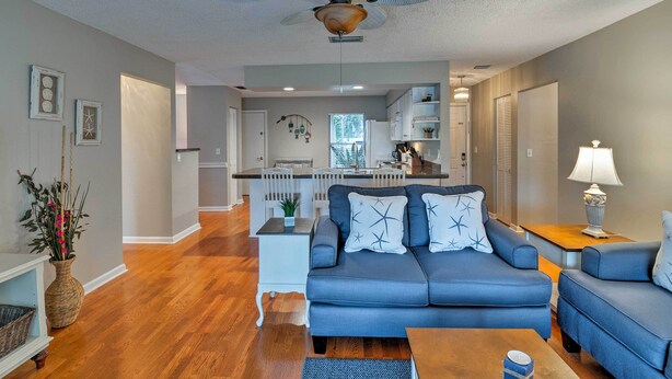 A modern living room with a blue sofa, a coffee table, and a ceiling fan. - Breezy Sarasota Home w/ Private Pool Near Beach! (Sarasota)