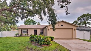 A single-story house with a front yard, a garage, and a covered patio area. - Breezy Sarasota Home w/ Private Pool Near Beach! (Sarasota)