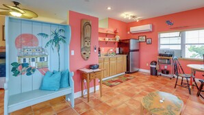 A kitchen with a wooden bench, a refrigerator, and a window with blinds. - Vibrant Condo - Walk to Indian Rocks Beach! (Indian Rocks Beach)
