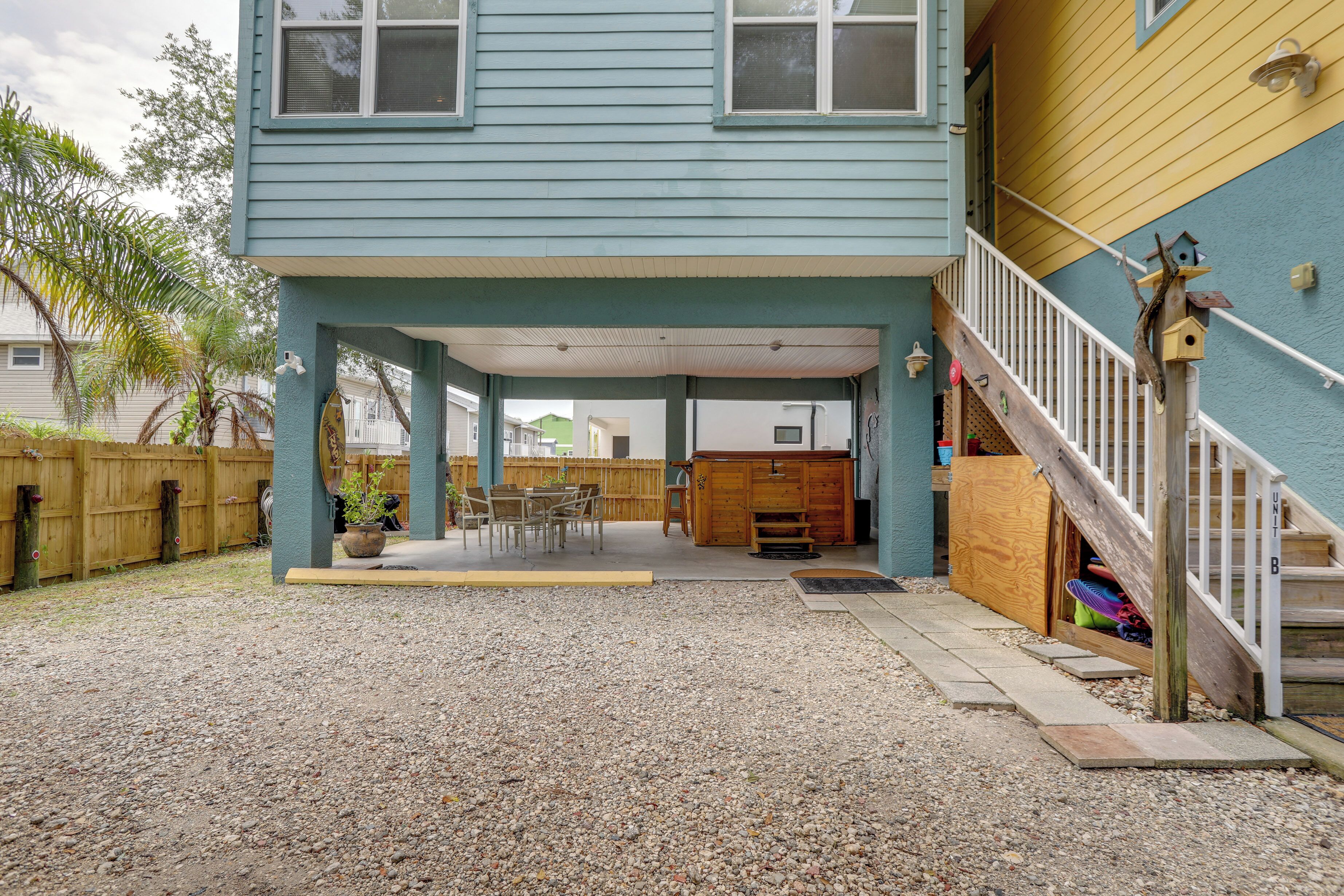 A covered patio area with a wooden deck, outdoor furniture, and a wooden playhouse.
