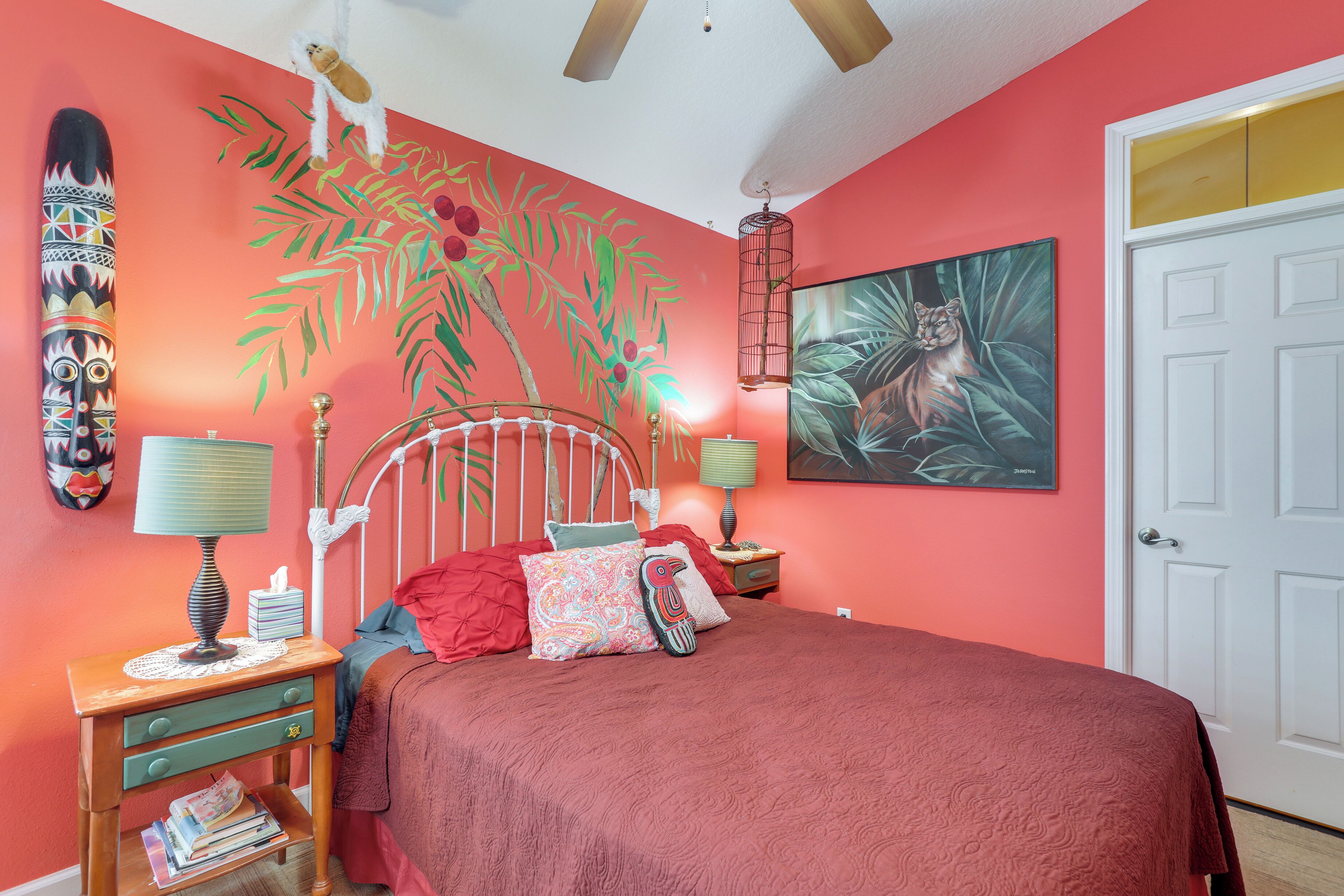 A bedroom with a bed, a nightstand, a lamp, and a door.