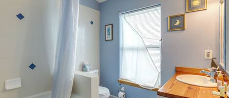 A bathroom with a bathtub, toilet, and sink.