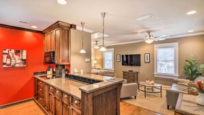 A modern kitchen with wooden cabinets, a granite countertop, and a built-in microwave.
