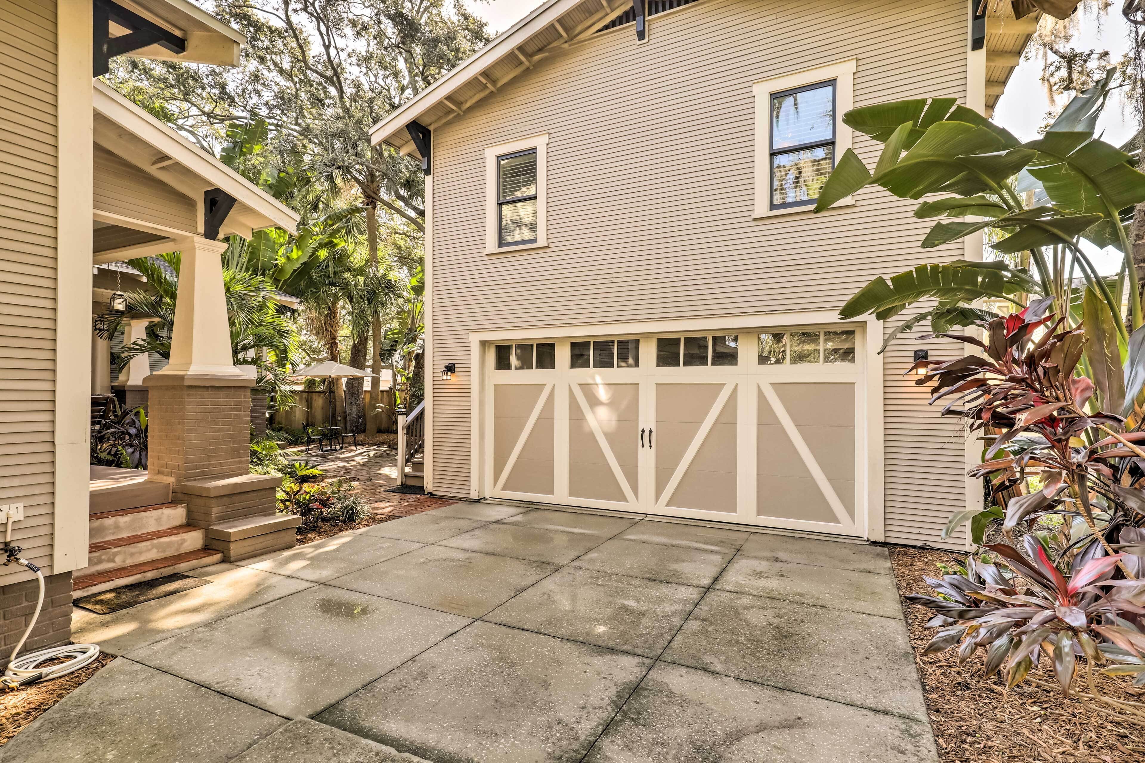 A two-story house with a garage, a covered porch, and a concrete driveway.