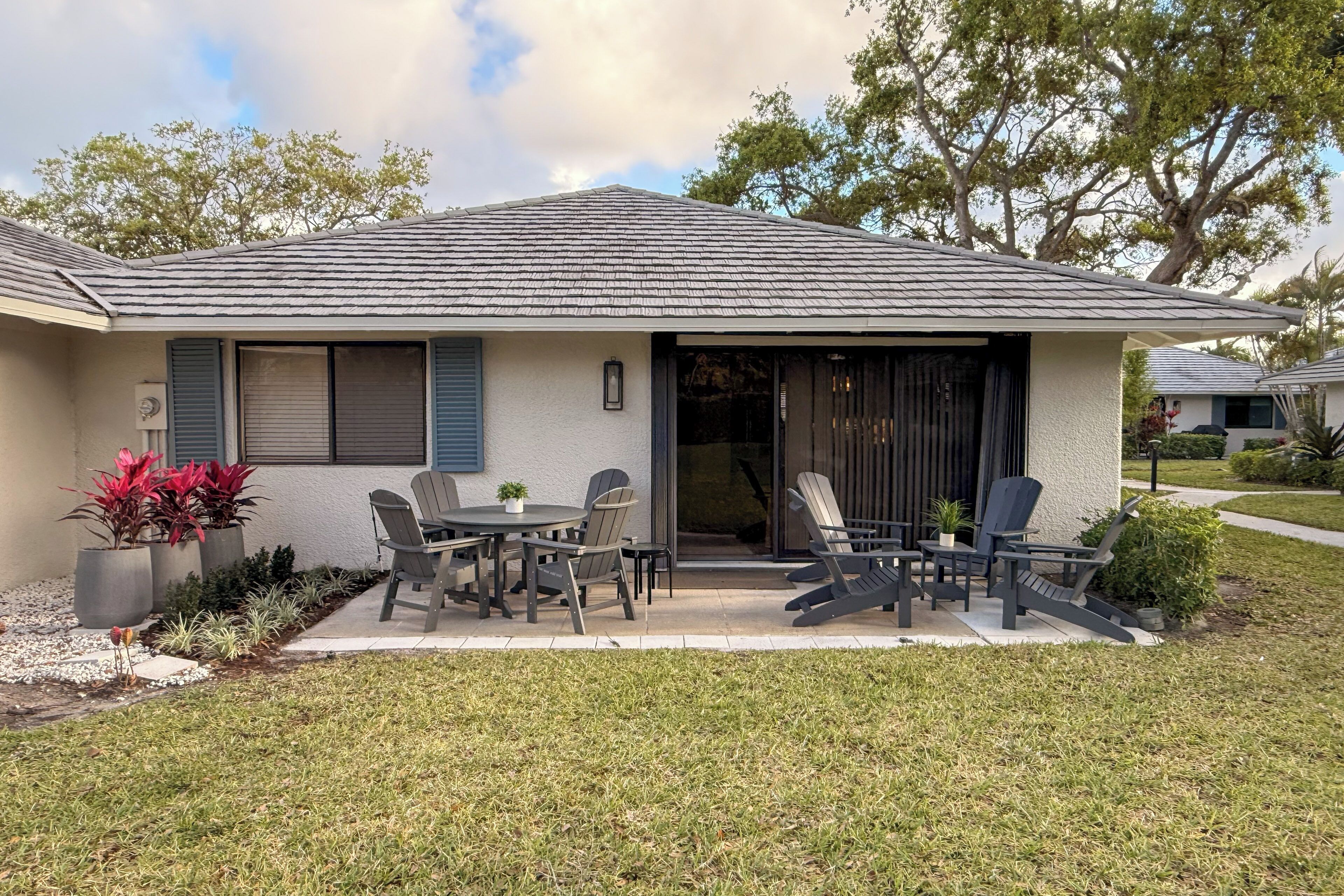 A house with a patio, outdoor seating, and a garage.