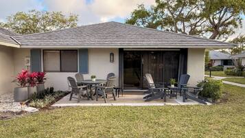 A house with a patio, outdoor seating, and a garage.