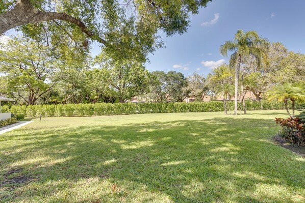 A well-maintained grassy area with trees and a clear sky.