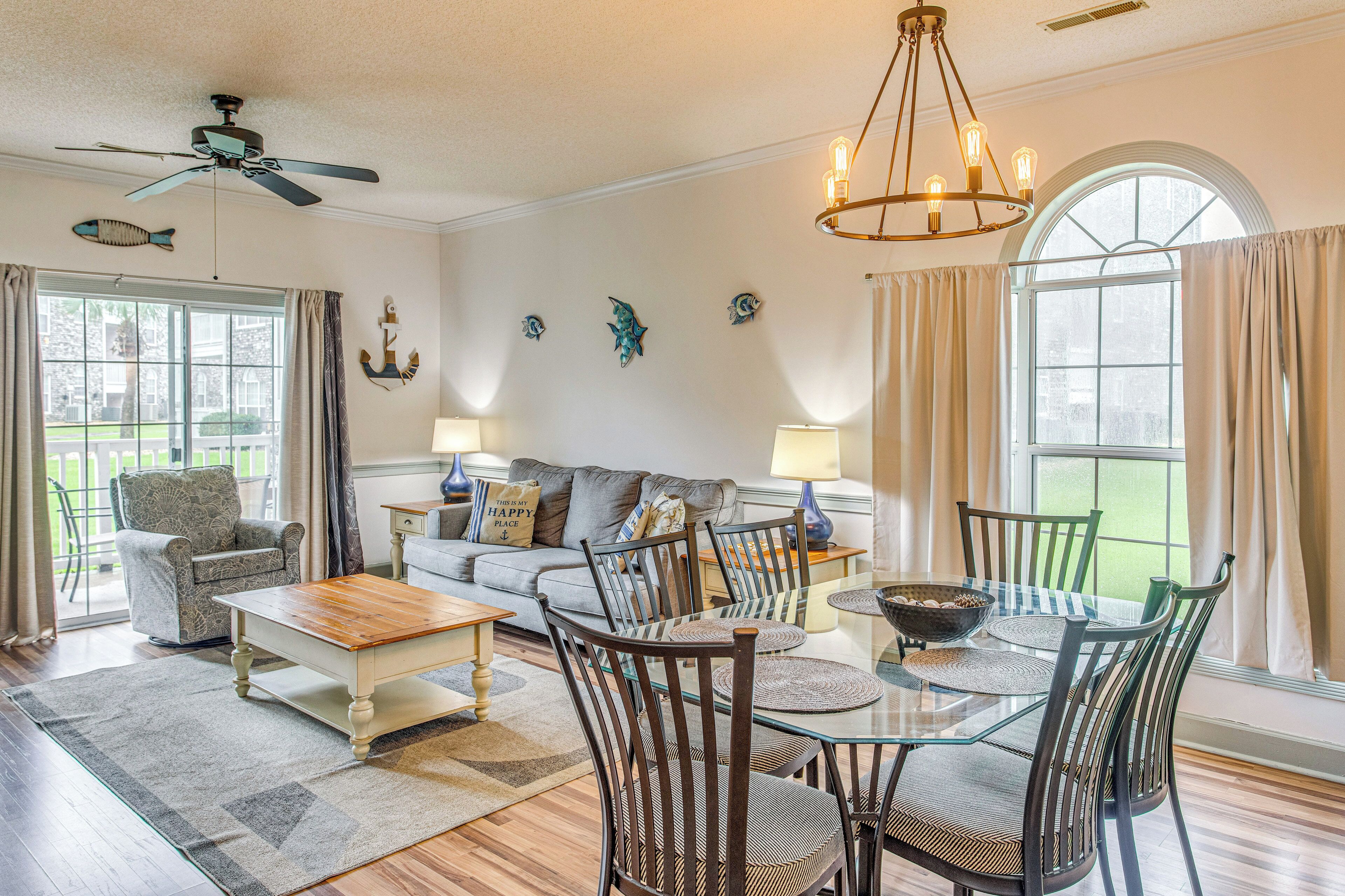 A spacious living room with a sofa, chairs, a coffee table, and a dining table.