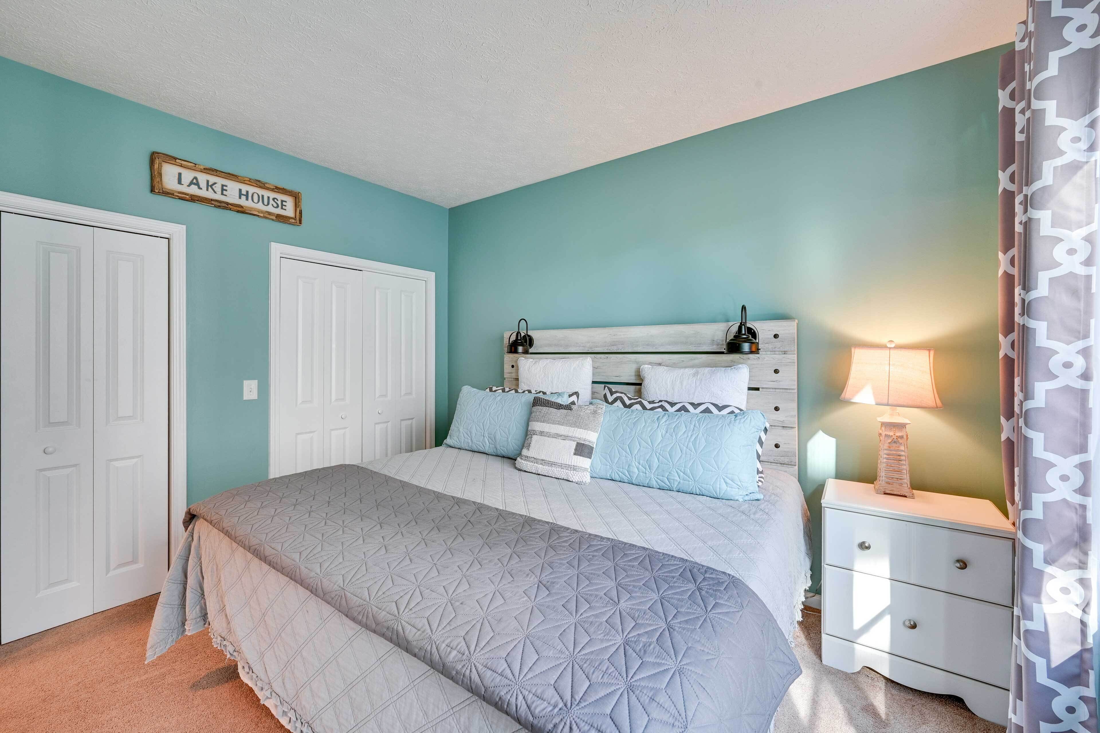 Un dormitorio con cama, mesita de noche y un cartel que dice 'LAKE HOUSE'.