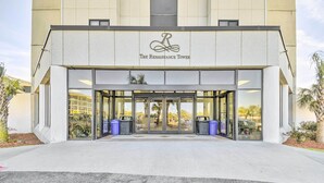 L’entrée de l’hôtel Renaissance Tower, avec sa façade moderne, ses grandes portes vitrées et une vue dégagée sur l’intérieur à travers le verre.
