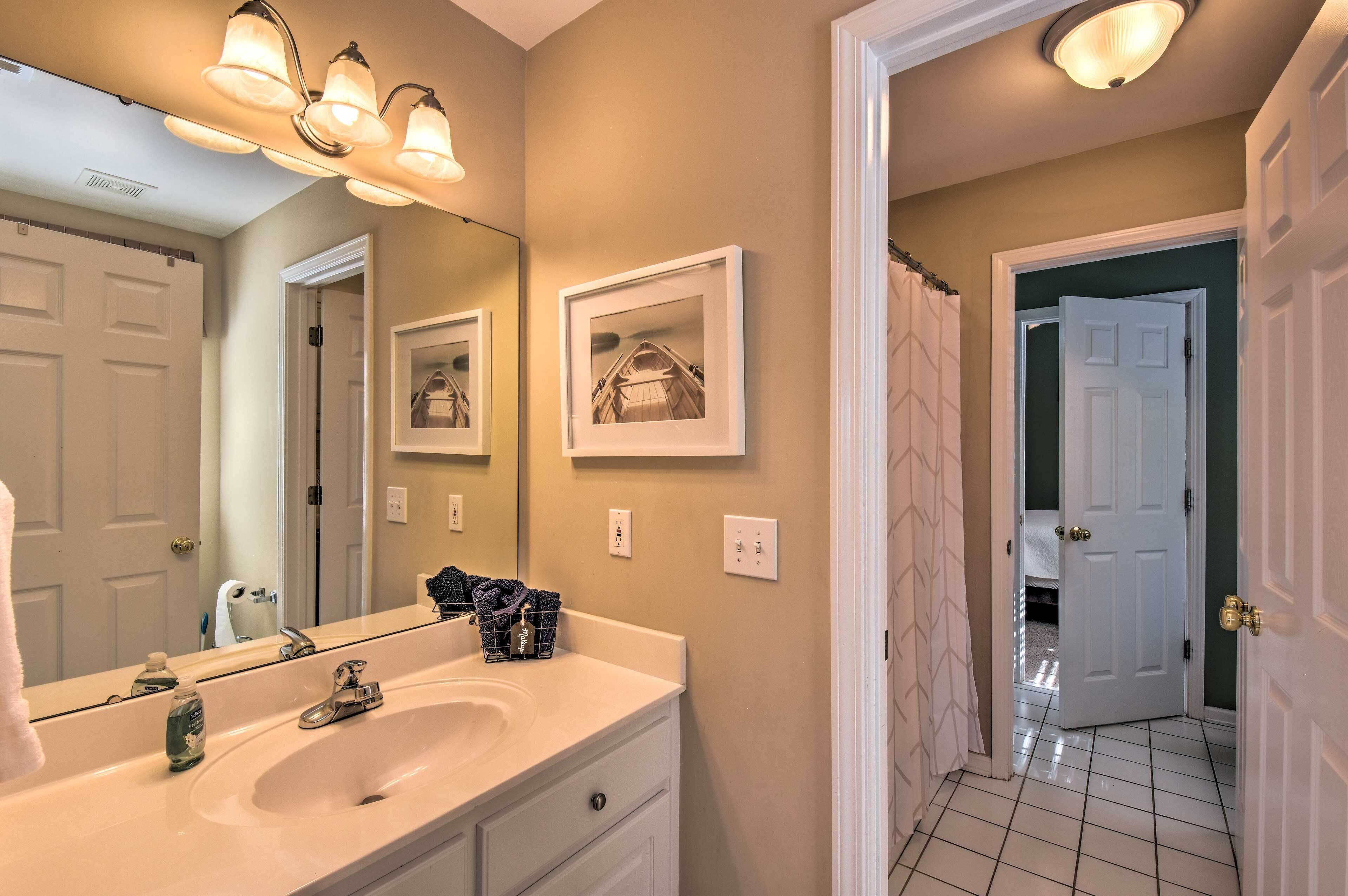 A bathroom with a white sink, a mirror, and a shower curtain.