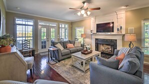 A spacious living room with a fireplace, a ceiling fan, and a large TV. - Lake Keowee Escape w/ Dock, Deck & Lake Access! (Six Mile)