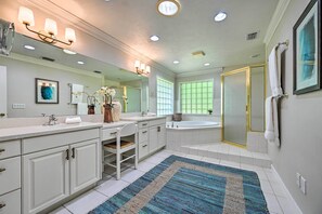A spacious bathroom with a large mirror, two sinks, a bathtub, and a walk-in shower. - Huge Lutz Family Retreat w/ Game Room & Pool! (Lutz)