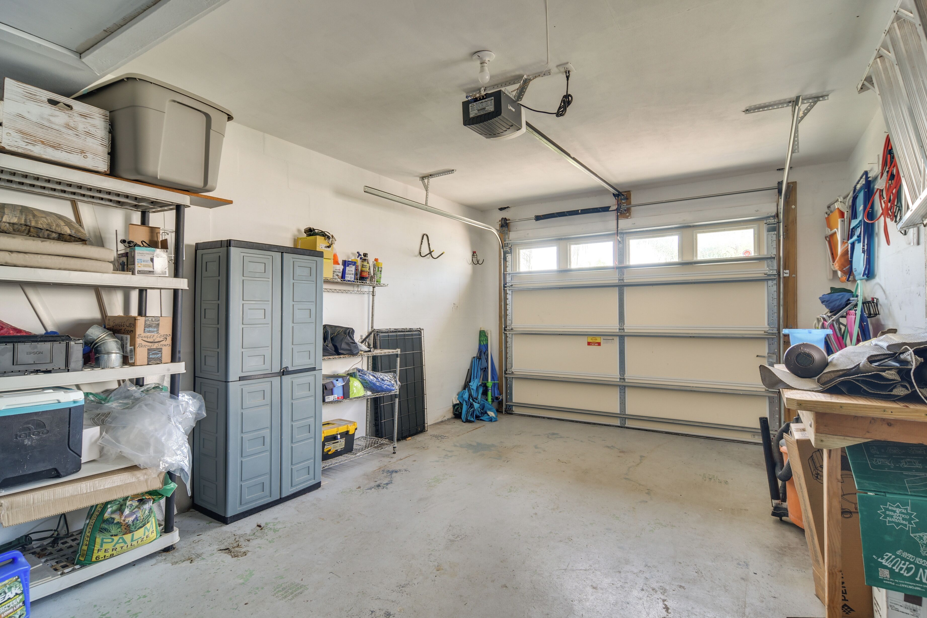 Un garage con armadietti, scaffali e un banco di lavoro.