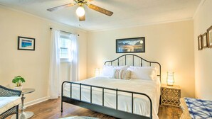 A bedroom with a bed, a ceiling fan, a window with curtains, a small table with a plant, and a framed picture on the wall. - Lovely Taylors Home: 8 Mi to Dtwn Greenville! (Taylors)