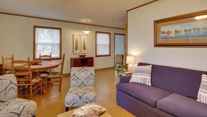 A living room with a purple sofa, patterned armchairs, a wooden dining table, and a painting on the wall. - Lakefront House w/ Boat Ramp, Dock & Sunset Views! (Cross Hill)