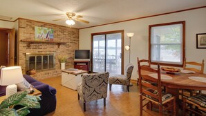 A living room with a fireplace, television, and dining area. - Lakefront House w/ Boat Ramp, Dock & Sunset Views! (Cross Hill)