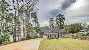 A residential property with a large driveway, a well-maintained lawn, and a house with a gabled roof. - Lakefront Leesville Retreat w/ Private Dock! (Leesville)