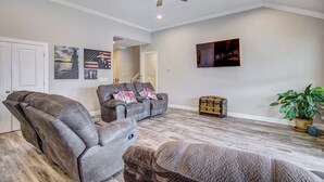 A spacious living room with two leather recliners, a grey sofa, and a wooden floor. - Lakefront Leesville Retreat w/ Private Dock! (Leesville)
