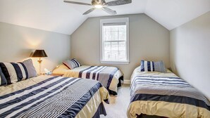 A bedroom with two beds, a ceiling fan, a window, and a nightstand with a lamp. - Lakefront Leesville Retreat w/ Private Dock! (Leesville)