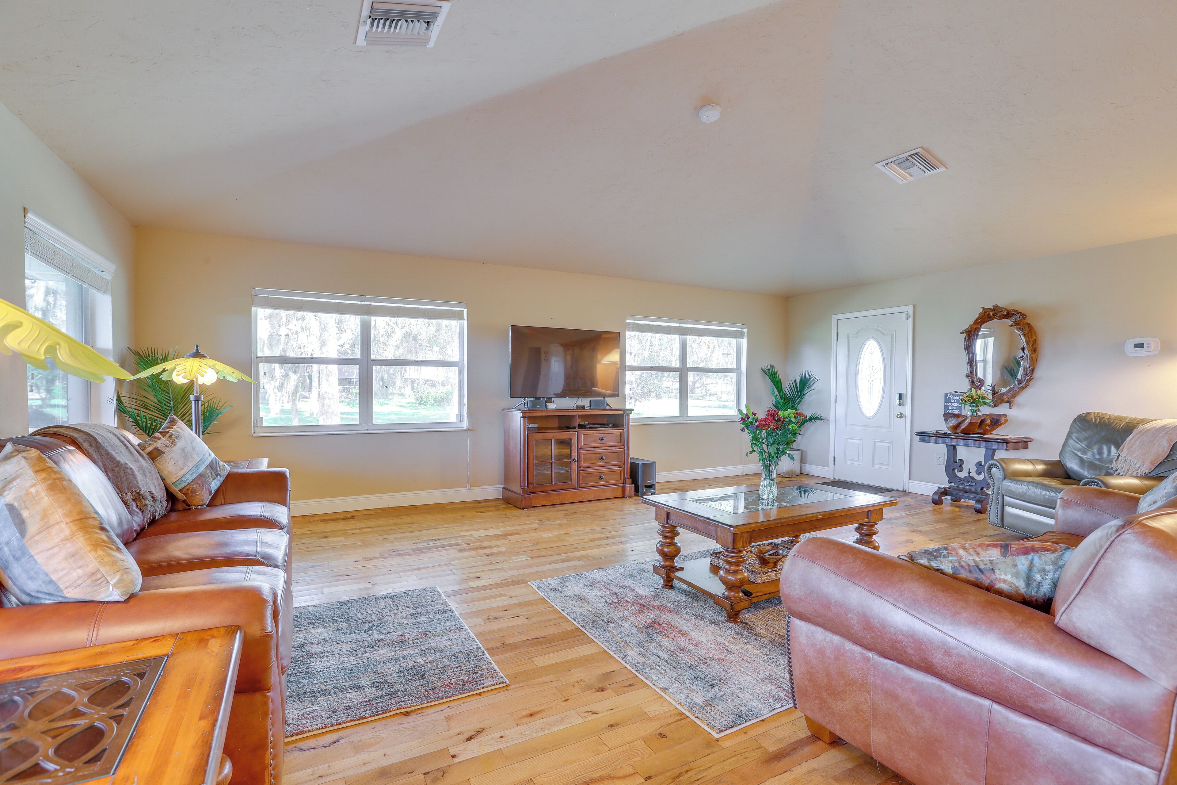 A spacious living room with a leather sofa, a coffee table, and a fireplace.