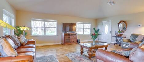 A spacious living room with a leather sofa, a coffee table, and a fireplace.