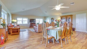 A spacious living area with a dining table, chairs, a sofa, and a fireplace.