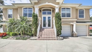 A two-story house with a front entrance, a driveway, and a garage.