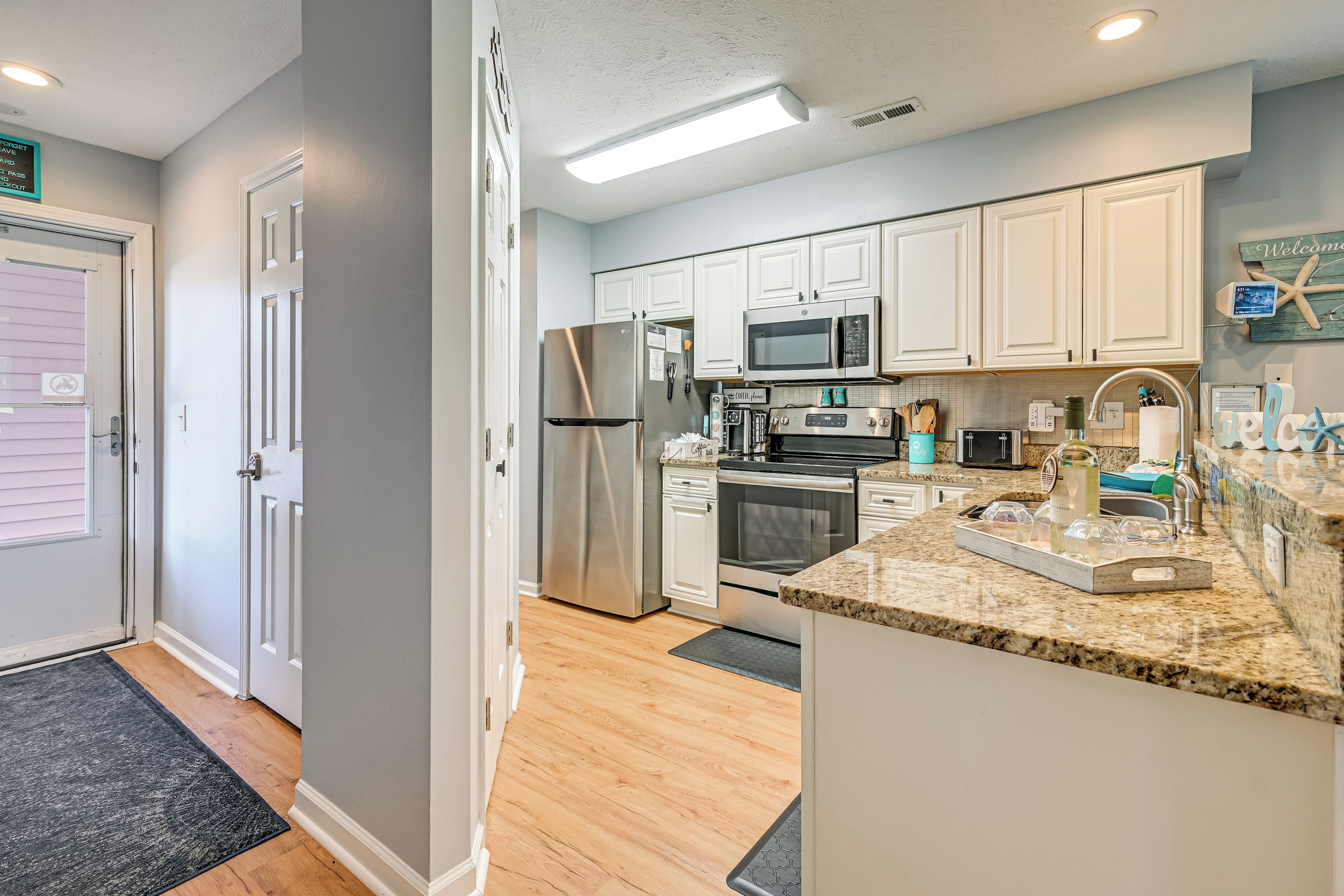 A modern kitchen with white cabinets, stainless steel appliances, and a granite countertop.