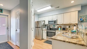 A modern kitchen with white cabinets, stainless steel appliances, and a granite countertop. - 1st-floor Condo w/ Pool on Intracoastal Waterway! (Myrtle Beach)