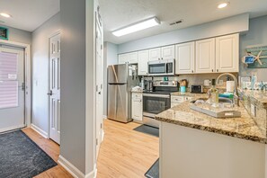 A modern kitchen with white cabinets, stainless steel appliances, and a granite countertop. - 1st-floor Condo w/ Pool on Intracoastal Waterway! (Myrtle Beach)