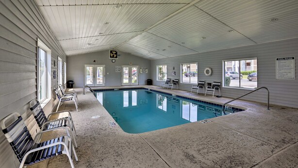 An indoor swimming pool with a tiled floor, benches along the sides, and a sign indicating pool rules. - 1st-floor Condo w/ Pool on Intracoastal Waterway! (Myrtle Beach)