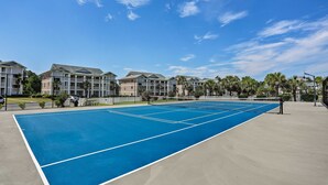 A tennis court surrounded by apartment buildings with a clear blue sky. - 1st-floor Condo w/ Pool on Intracoastal Waterway! (Myrtle Beach)