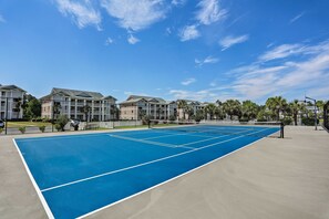 A tennis court surrounded by apartment buildings with a clear blue sky. - 1st-floor Condo w/ Pool on Intracoastal Waterway! (Myrtle Beach)