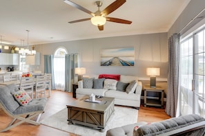 A spacious living room with a ceiling fan, a dining area with a white table and chairs, and a kitchen in the background. - < 2 Mi to Coast: Condo w/ Pool in Myrtle Beach (Myrtle Beach)