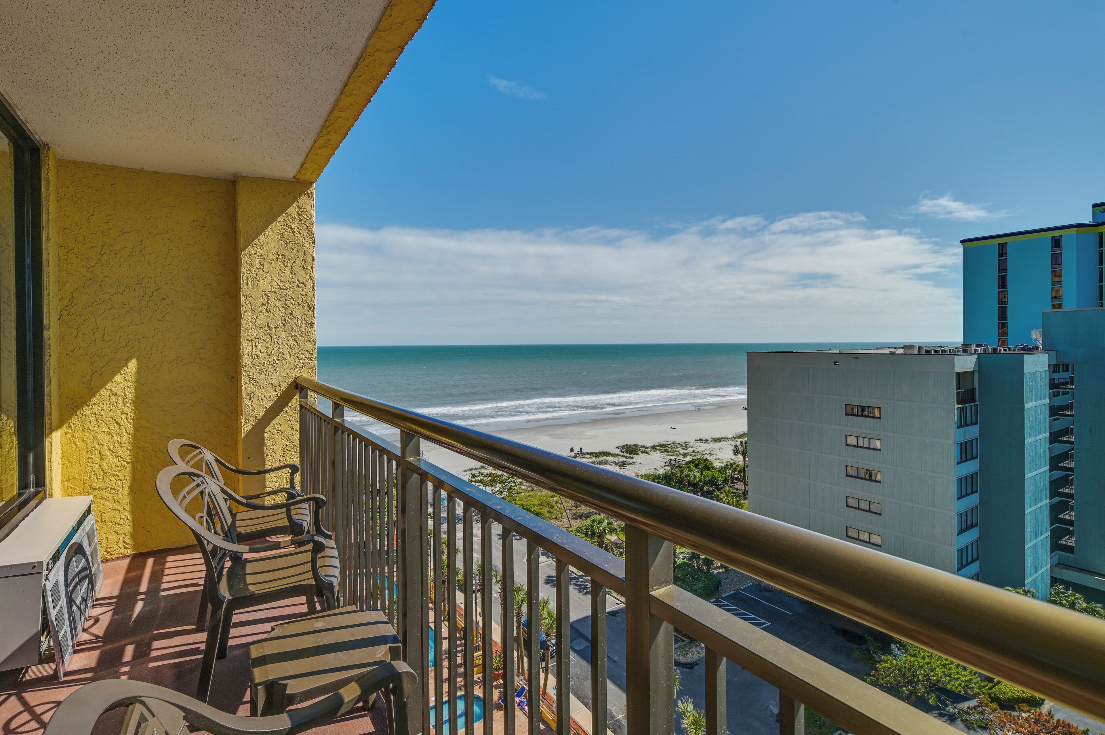 Un balcon avec vue sur la plage et l’océan.