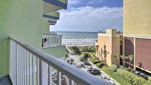 Ein Balkon mit Blick auf Strand und Meer.