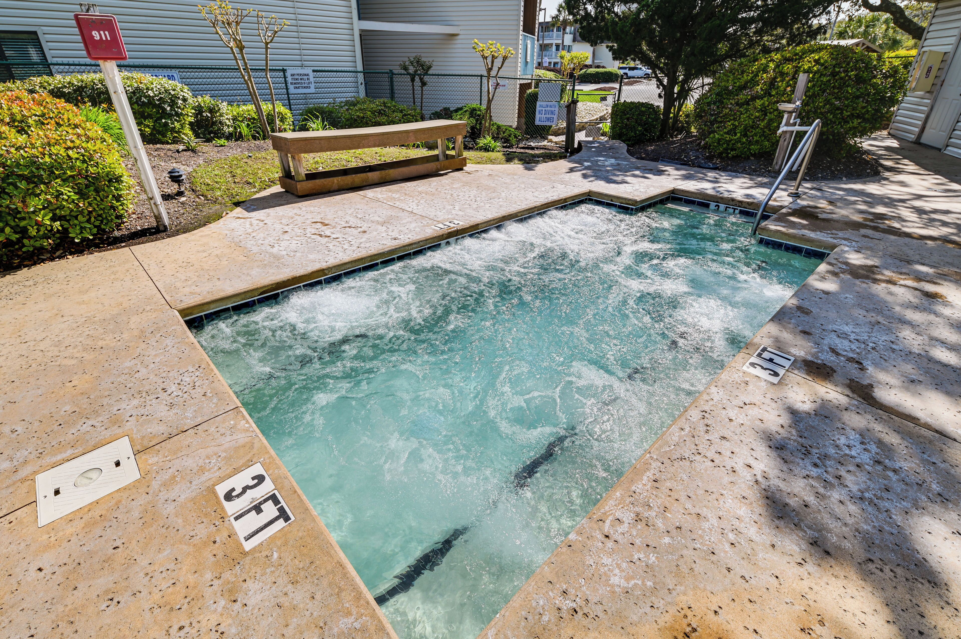 A swimming pool with a bench and a lifeguard stand.