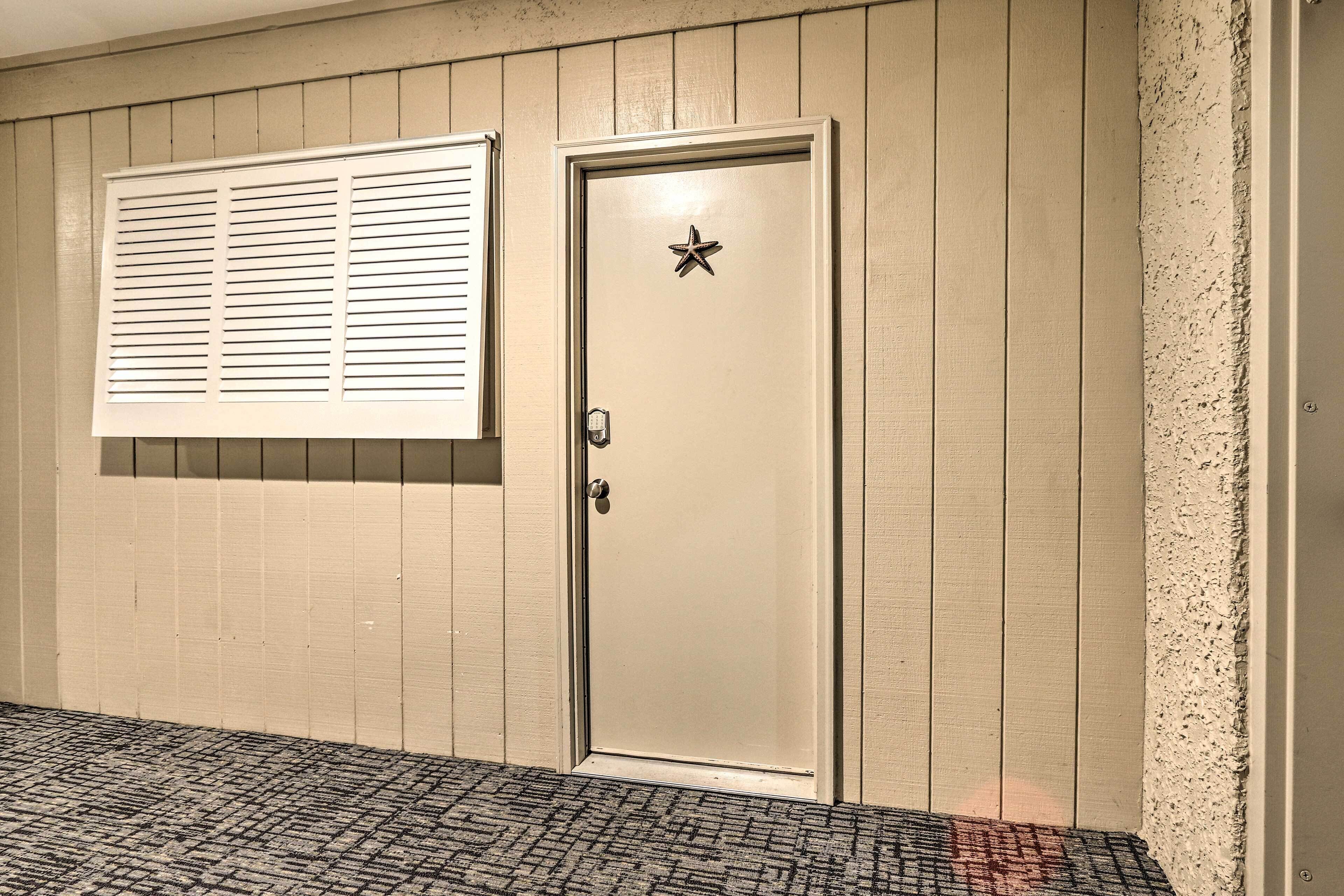 Eine beige Tür mit Sterndekoration, ein Fenster mit Jalousien und eine strukturierte Wand.