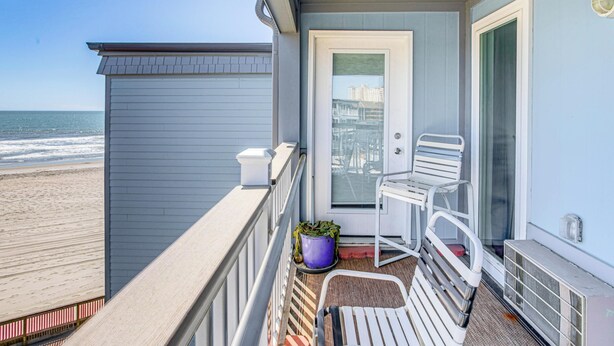 A balcony with a view of the beach, a door, a chair, and a potted plant. - ~ 9 Mi to Boardwalk: Oceanfront Myrtle Beach Condo (Myrtle Beach)