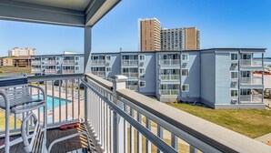 A balcony with a pool, multiple-story buildings, and a clear sky. - ~ 9 Mi to Boardwalk: Oceanfront Myrtle Beach Condo (Myrtle Beach)