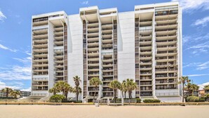 A multi-story hotel with balconies, located near a beach. - Oceanfront Myrtle Beach Condo w/ Outdoor Pool (Myrtle Beach)